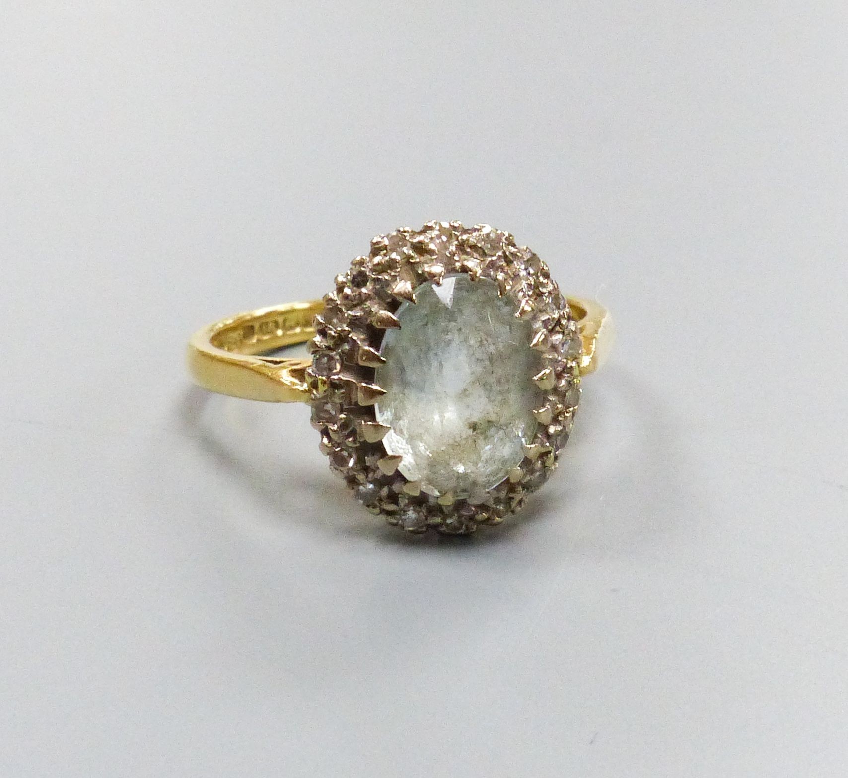 An 18ct gold, aquamarine and diamond cluster ring, size L, gross weight 3.9 grams.